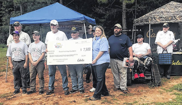 The Freedom and Hope Foundation received a $7,500 donation from Bass Pro Shops and Cabelas Outdoor Fund. Pictured, left to right, Board Members Dean Fellers, Gene Fellers, Terry Cotney, John Fabro, Collette Brooks (presenting the check), Shaun Robey and Chairman Dean Young (in the back row). Track chair photo, Darryl Wallace and Gerald White.
                                 Courtesy photo
