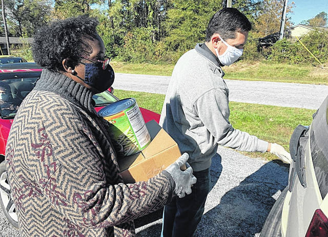 <p>Rev. Mia McDowell and Rev. Matthew Titus load up a car with food during a Living Hope Foundation food distribution event.</p>
<p>Courtesy photo</p>