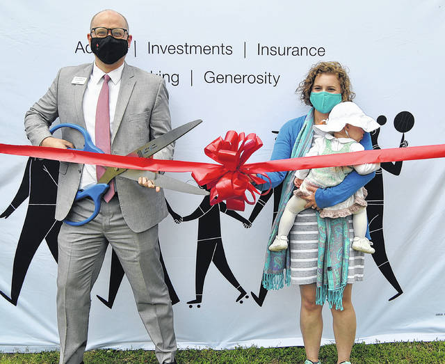 Robert Kopp (right) cuts the ribbon as the new Thrivent financial associate in Newberry. He is pictured with his wife, Mary Alex and their daughter, Palmer.
                                 Andrew Wigger | The Newberry Observer