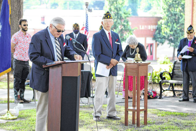 Jimmie Coggins calls out the number of deaths from each U.S. war or conflict as Eugene Wilson, American Legion Post 219, rings a bell.
                                 Andrew Wigger | The Newberry Observer
