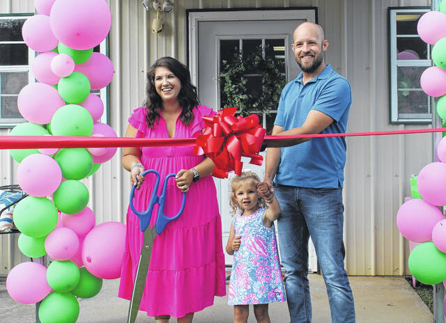Megan Lowe with daughter Emma and husband Eric cut the ribbon at Back to the Rack, 2671 Wheeland School Road, Prosperity.
                                 Andy Husk | The Newberry Observer