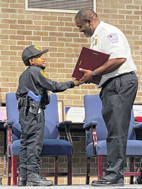 128721441_web1_IMG_4218
Police Chief Kevin Goodman presents DJ Daniel with his oath of office on a plaque bearing an official corporal badge.
Courtesy of NPD