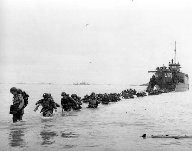 130638808_web1_130318876-5699c2f99edf430ea8763ee44133c360
FILE - U.S. reinforcements wade through the surf from a landing craft in the days following D-Day and the Allied invasion of Nazi-occupied France at Normandy in June 1944 during World War II. France is getting ready to show its gratitude towards World War II veterans who will come, many for the last time, on Normandy beaches for D-Day ceremonies that will come as part of a series of major commemorations this year and next marking eight decades since the defeat of the Nazis. (Bert Brandt/Pool via AP, File)