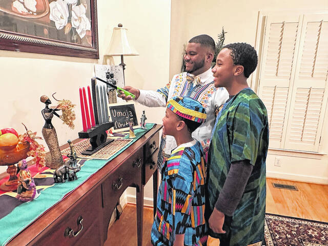 131157668_web1_C.-Kinard-Kwanzaa-Photo--Nephews--resized
City Councilman Carlton Kinard lighting the black candle Umoja (Unity) with his nephews Garrett and Christon by his side.
Courtesy photos